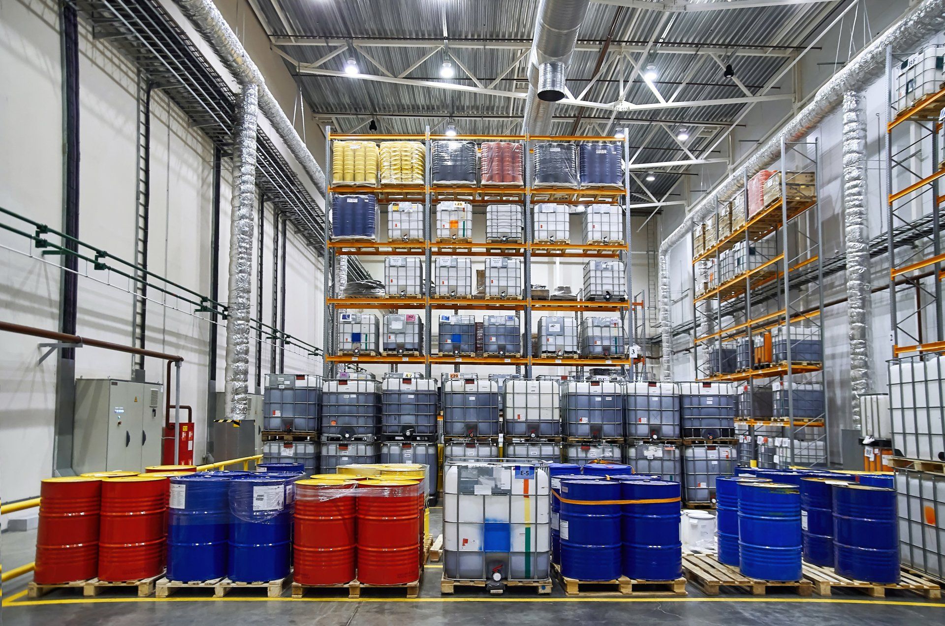 A large warehouse filled with lots of barrels and containers.