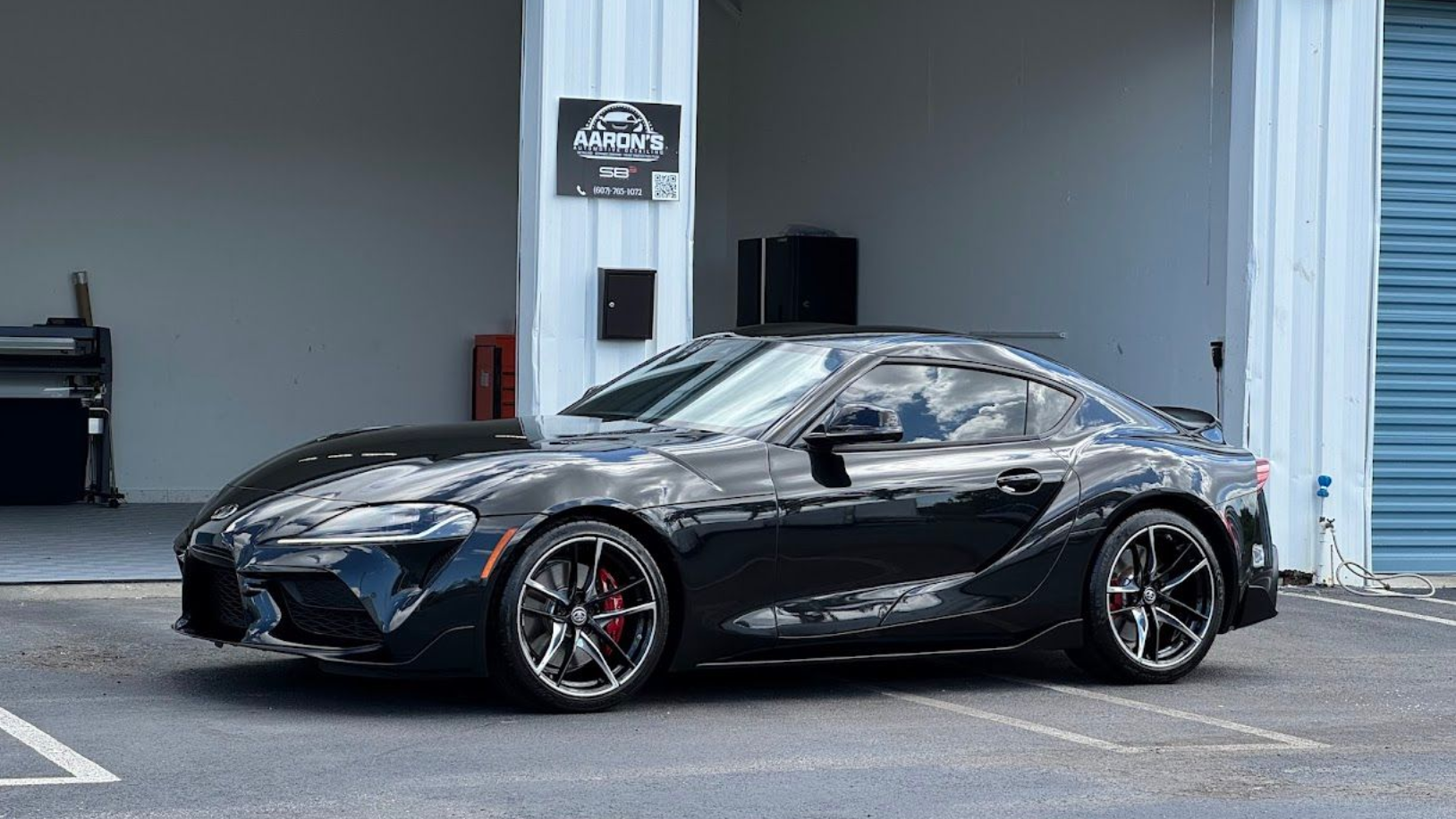 Black Toyota Supra sports car parked outside a building.