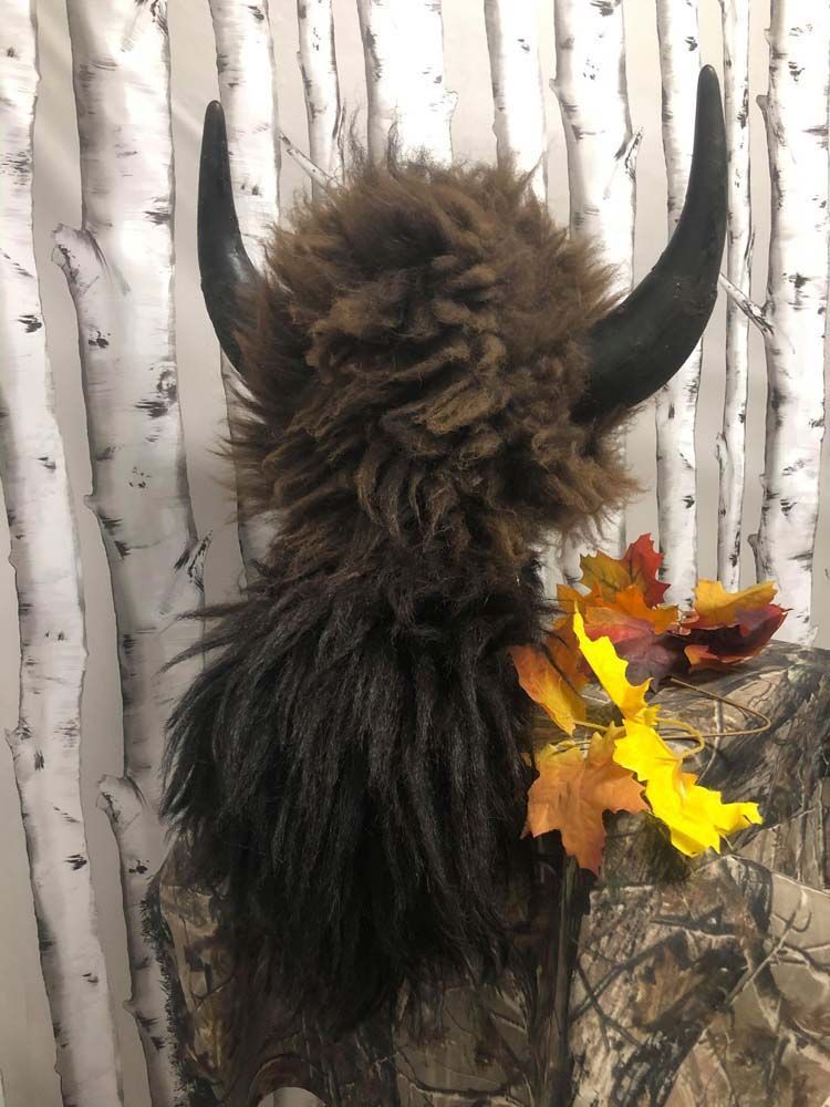 A close up of a buffalo costume with horns and leaves.