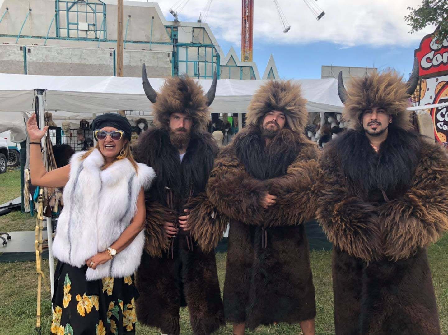 A group of people dressed in fur coats and horns are standing next to each other.