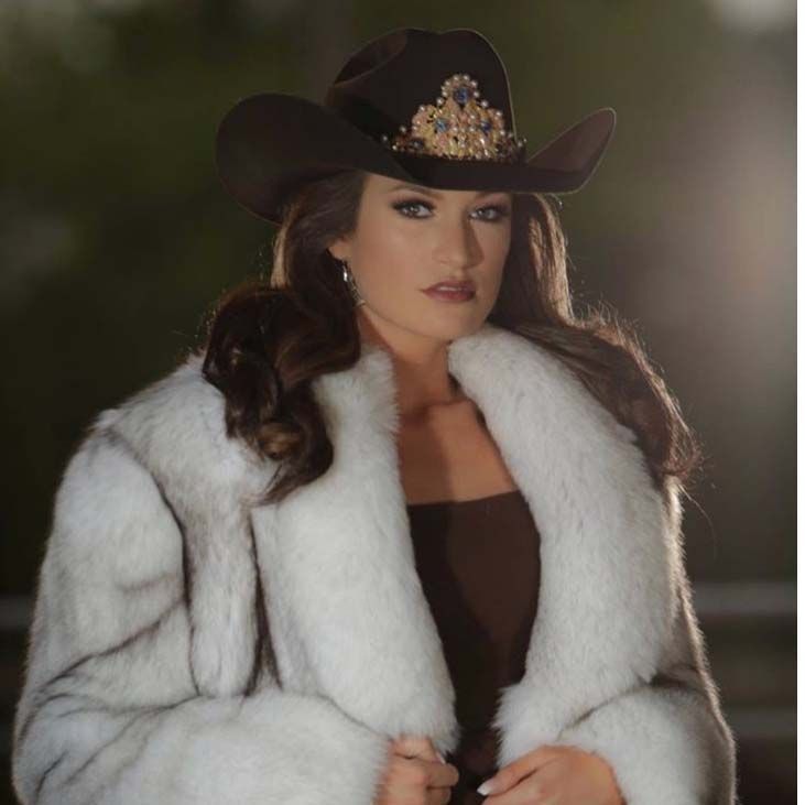 A woman wearing a cowboy hat and a white fur coat