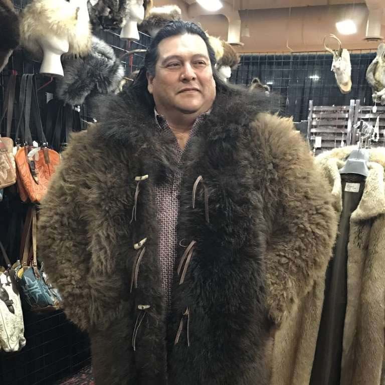 A man in a fur coat is standing in a store