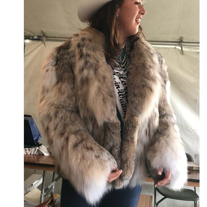 A woman wearing a fur coat and a cowboy hat
