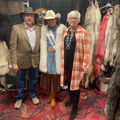 A group of people standing next to each other in a room filled with furs.