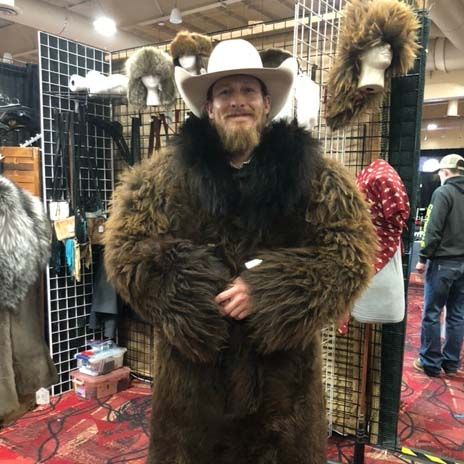 A man wearing a cowboy hat and a fur coat