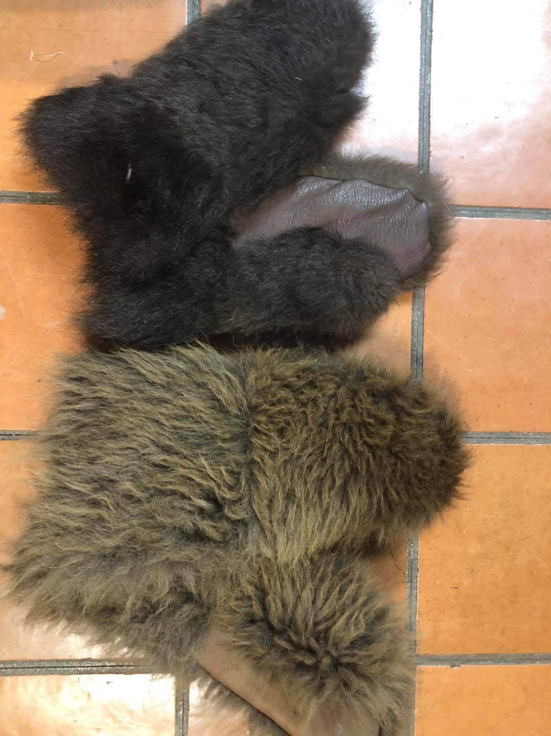 Three pieces of fur are sitting on a tiled floor.