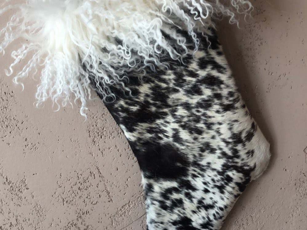 A black and white christmas stocking with a white fur trim