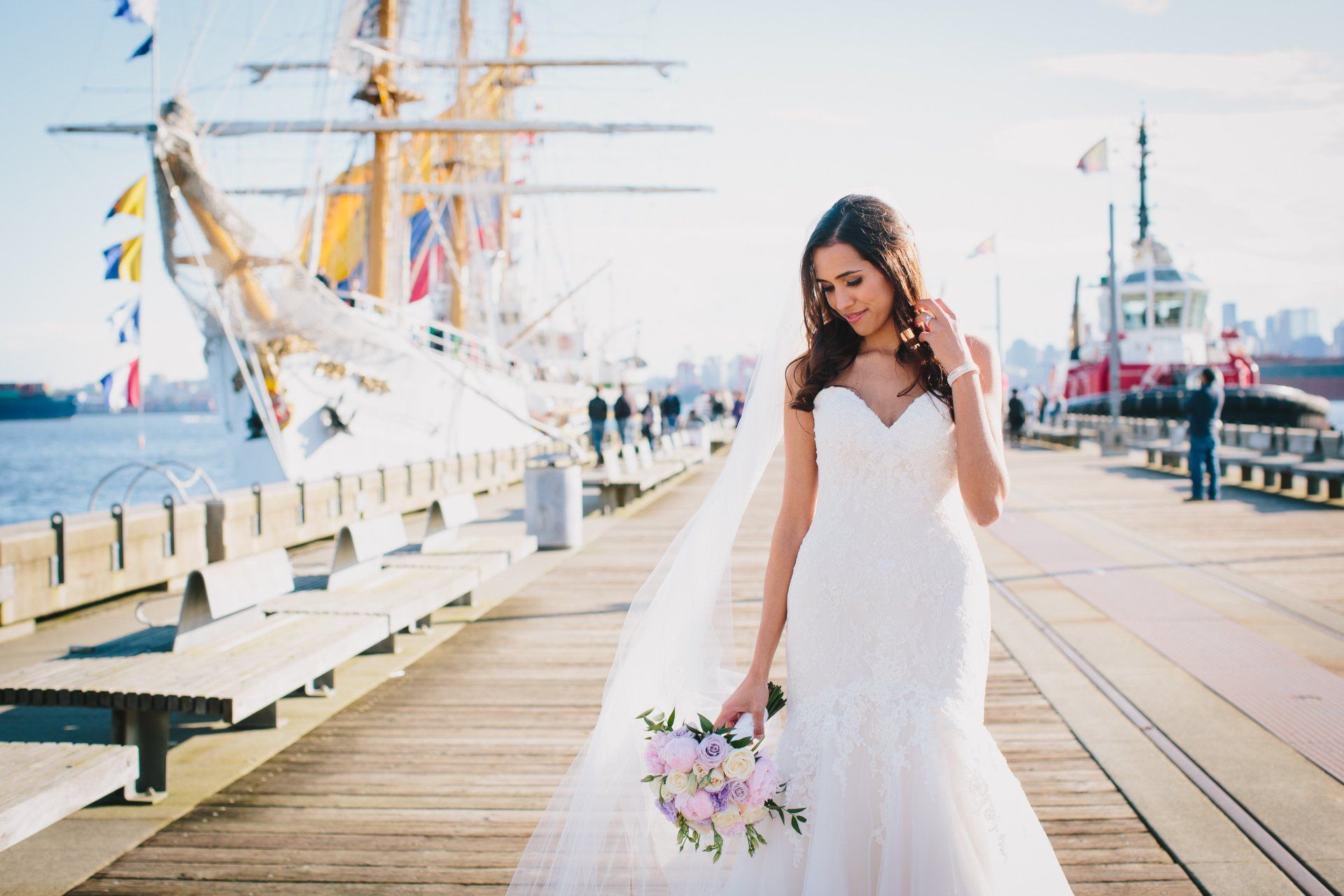 Bride walking down the dock playing with her hair