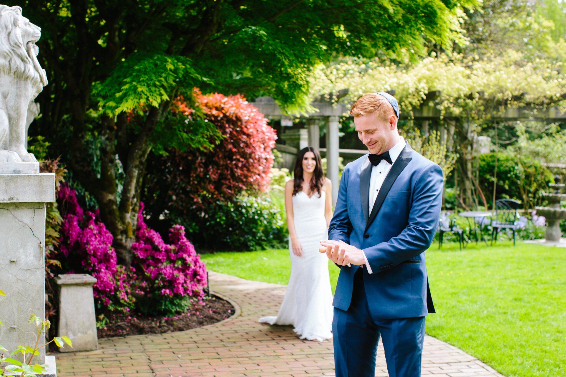 A bride and groom walking down a park path