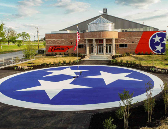 Tennessee-style building with large blue star logo in front and red script sign on the facade