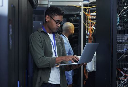 Vault Technologies IT technician working on a laptop in a server room