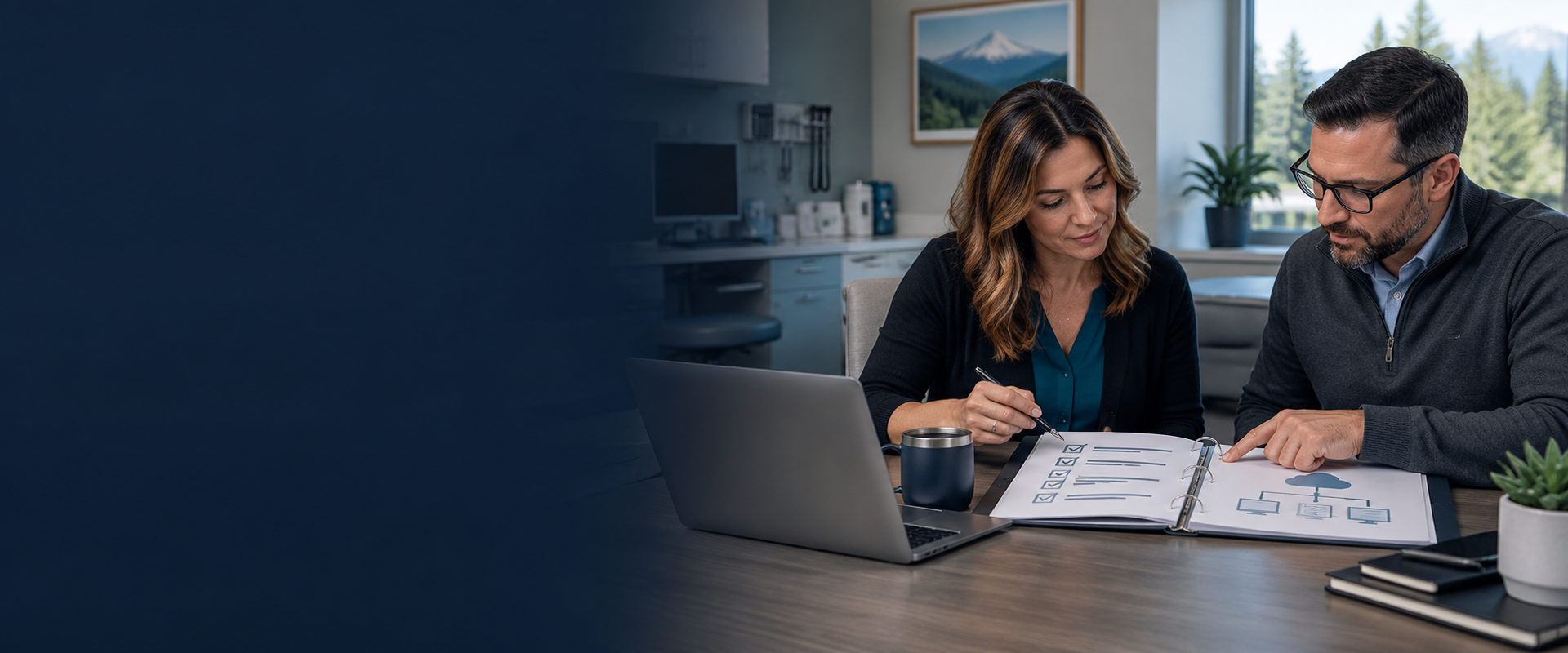 Healthcare administrator and IT professional review an organized technology documentation binder in