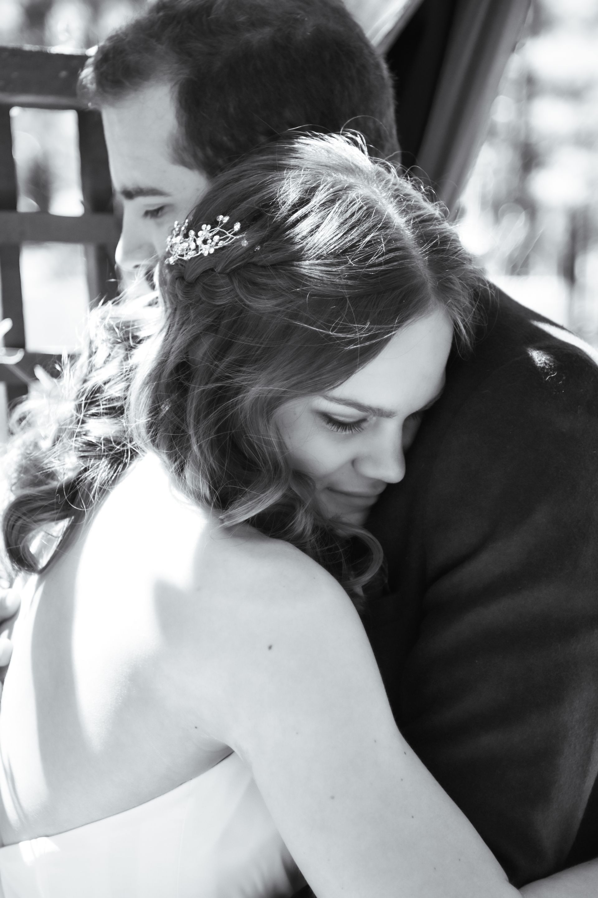A black and white photo of a bride and groom hugging