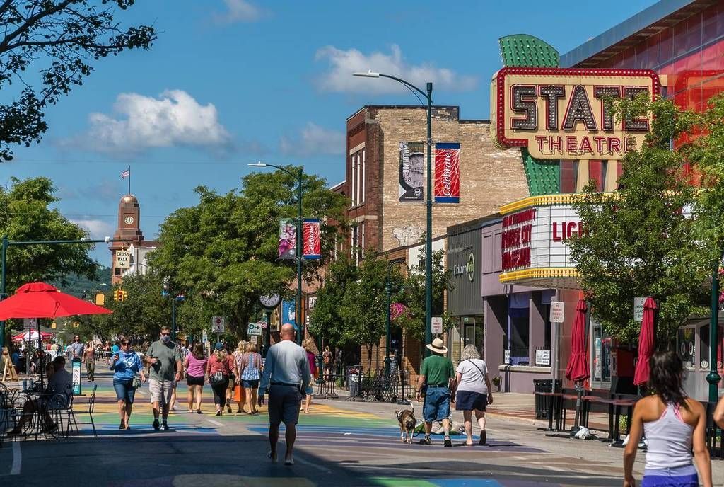 Busy downtown street with the State Theatre marquee. People walking under a sunny sky.