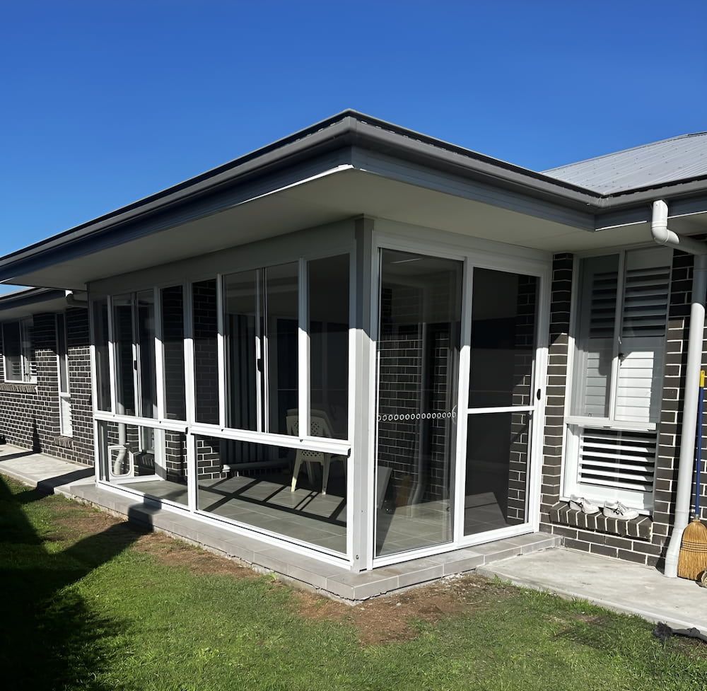 A House With A Lot Of Windows And Shutters On It — Hunter Home Services in Thornton, NSW