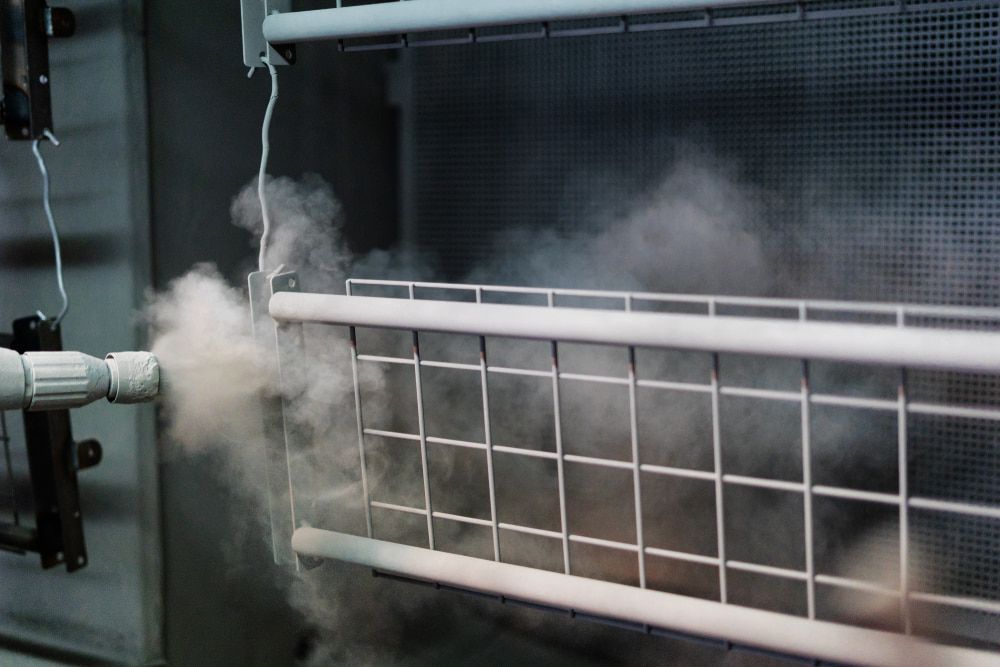 A Machine Is Spraying Powder on A Metal Fence — Leisure Coast Powder Coaters in Unanderra, NSW