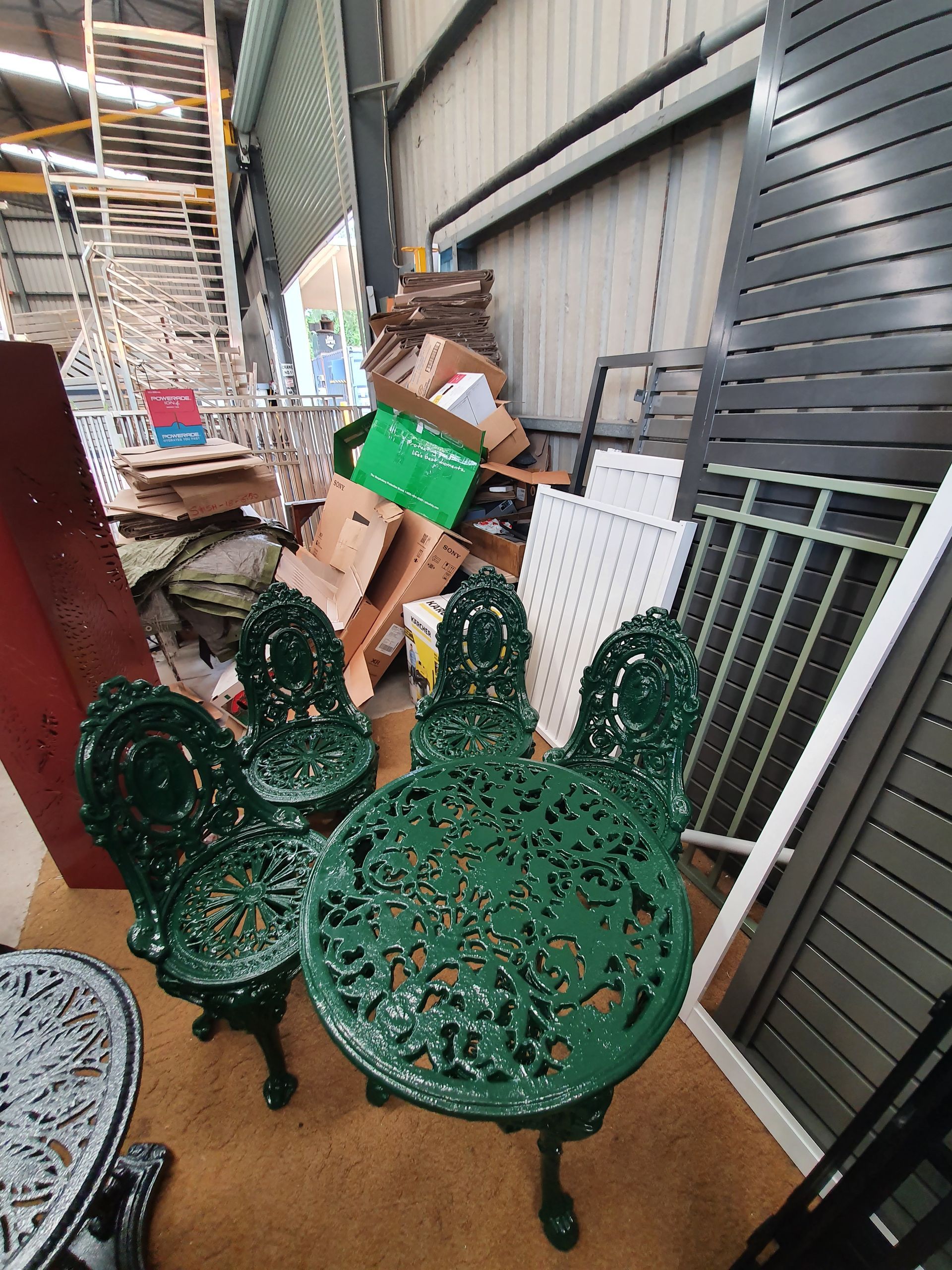 A Green Table and Chairs Are Sitting in A Warehouse — Leisure Coast Powder Coaters in Unanderra, NSW