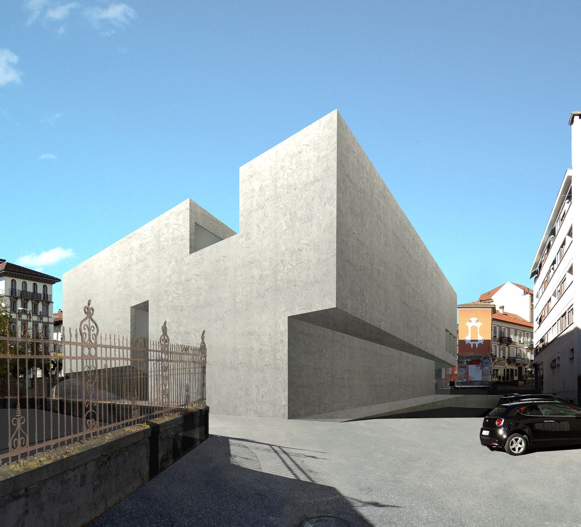 Un moderno edificio in cemento dal design semplice. Un'auto nera è parcheggiata lì vicino, su una strada acciottolata.