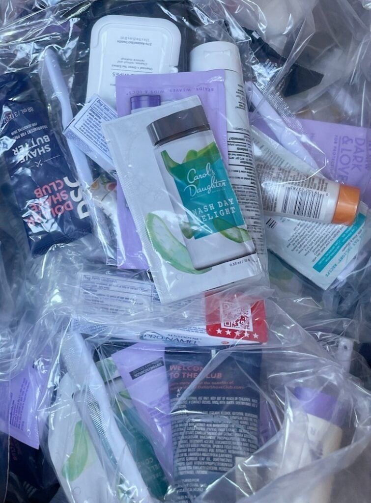 Pile of beauty product samples in clear plastic, including packets and tubes.