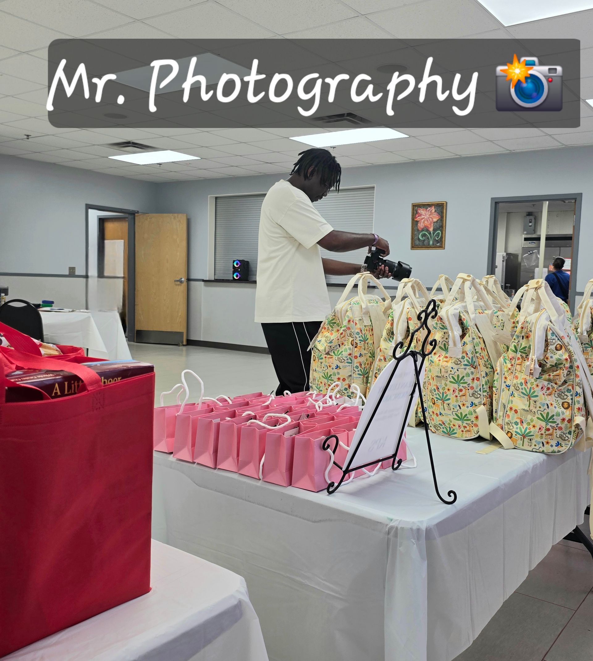 Vendor arranging colorful gift bags at a table in a community room