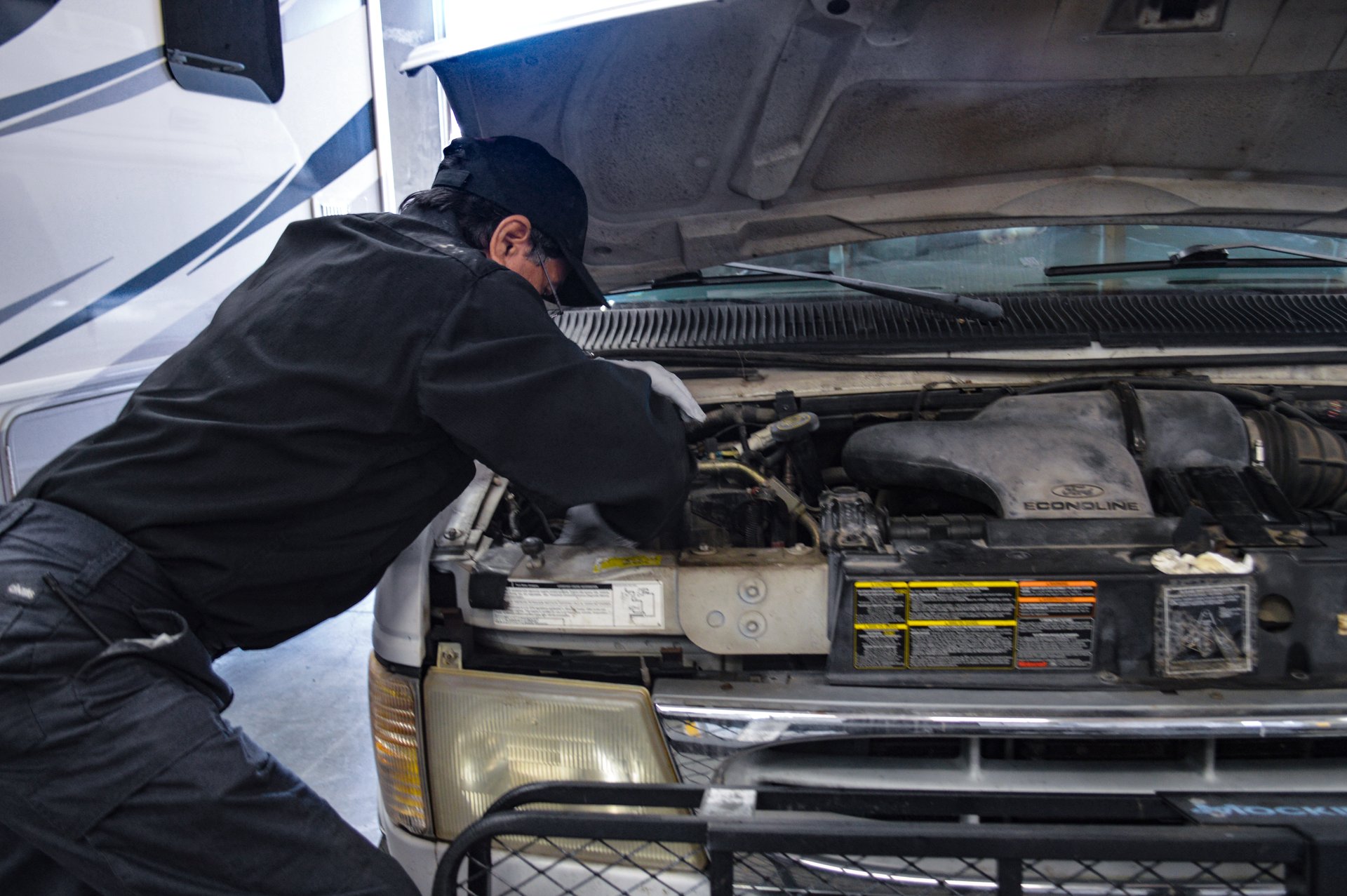 Mechanic inspecting a car engine with the hood open in a garage | Redhawk Auto Service - Temecula