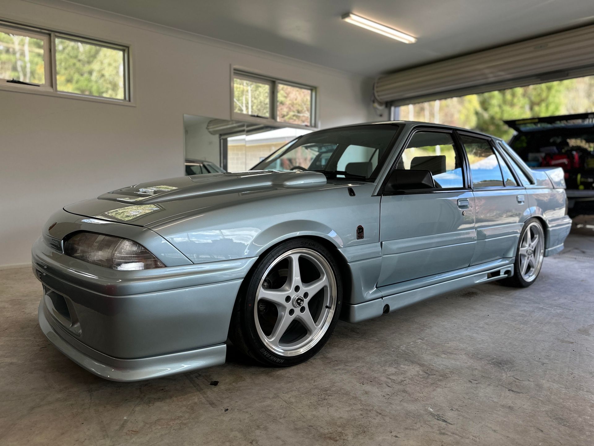 A silver car is parked in a garage.