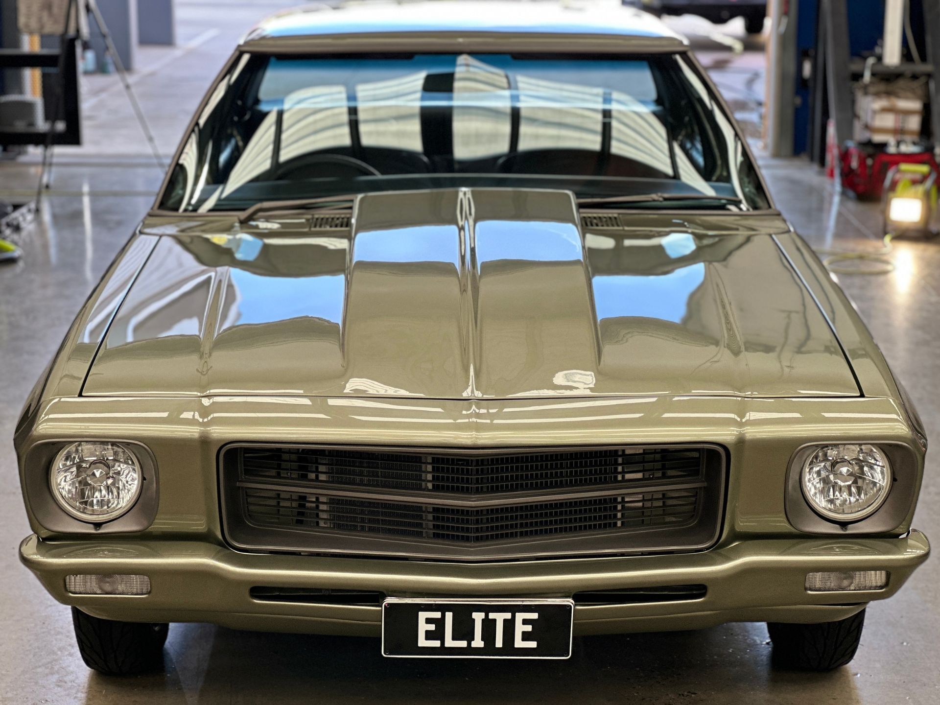 A car with a license plate that says elite is parked in a garage.