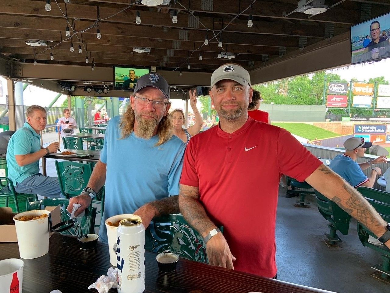 Two men are standing next to each other in a restaurant.