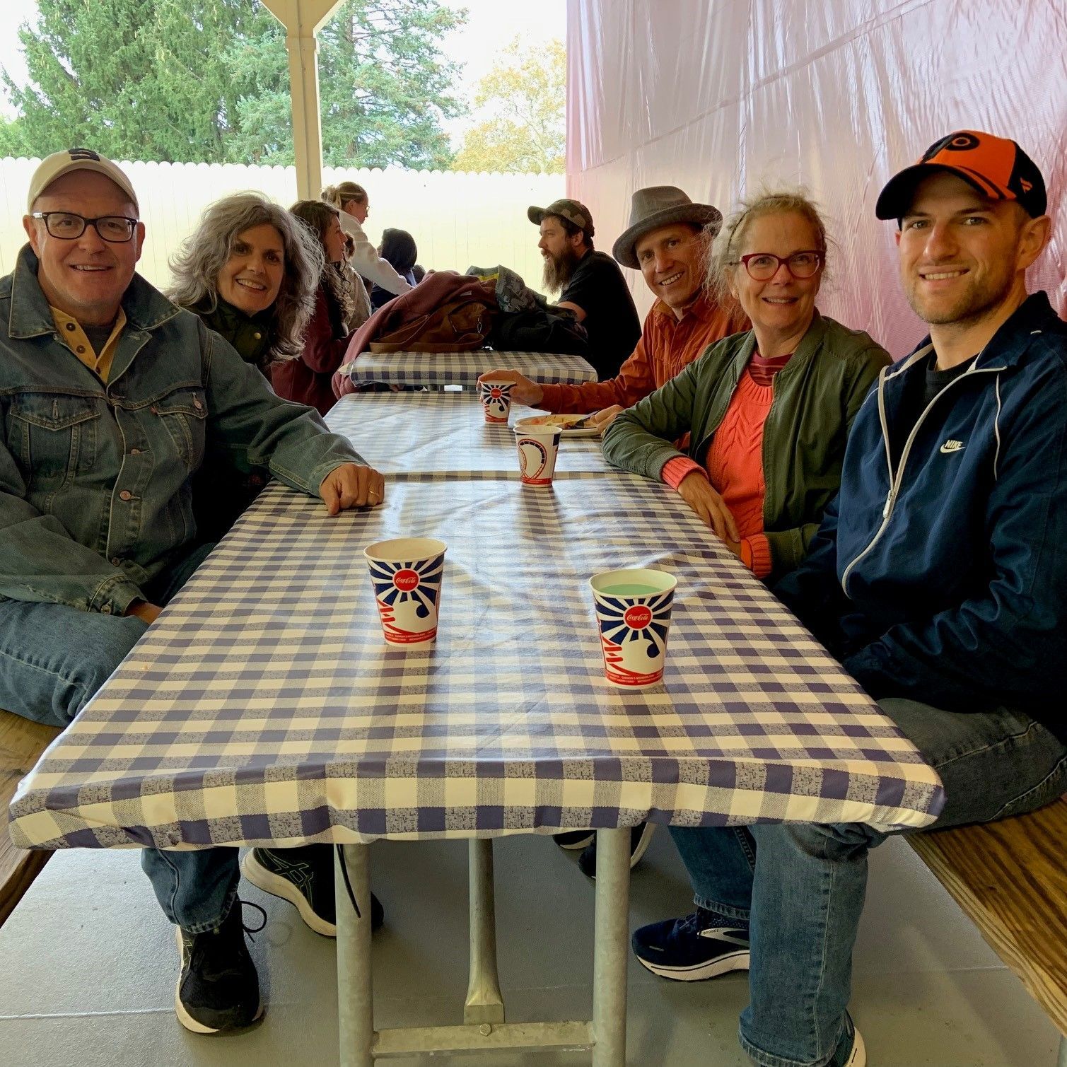 A group of people from Nauman Inc. are sitting at a table with cups on it.