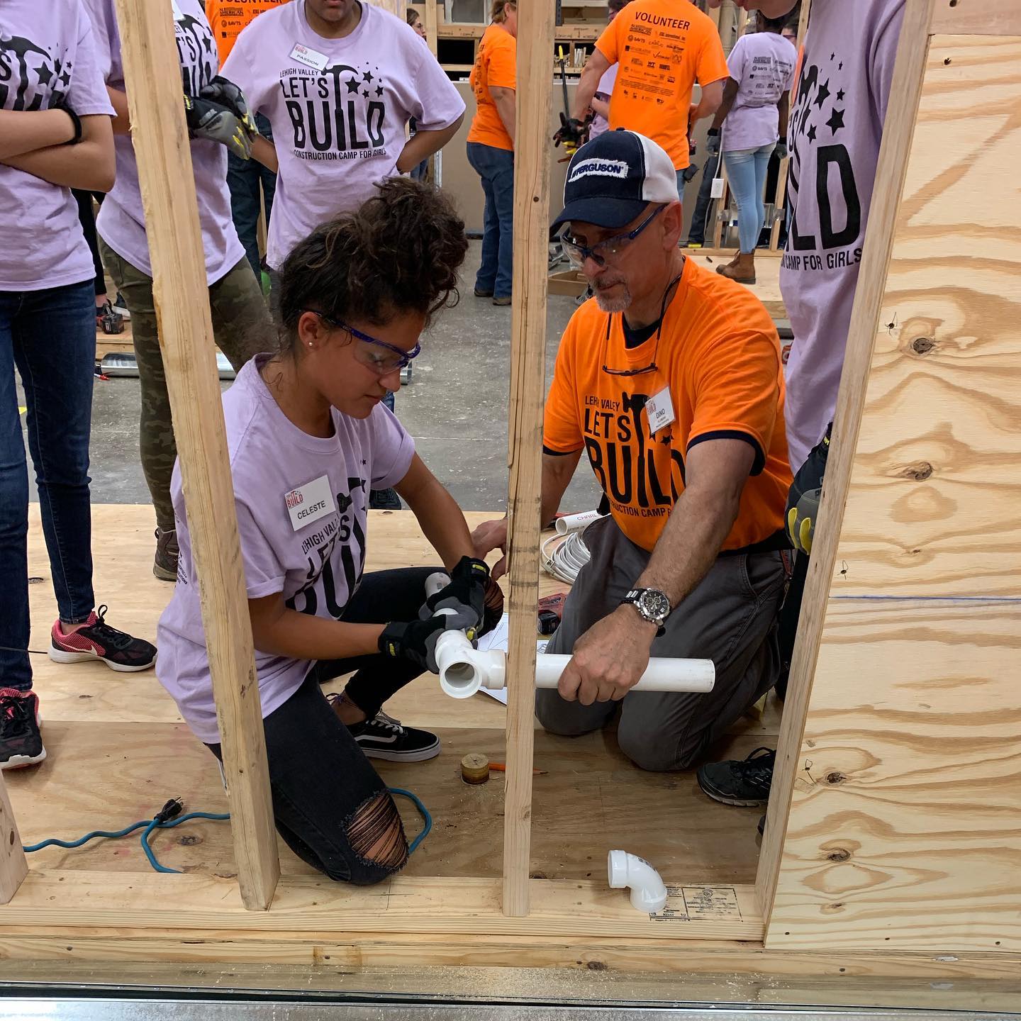 A group of people wearing shirts that say build are working on a project