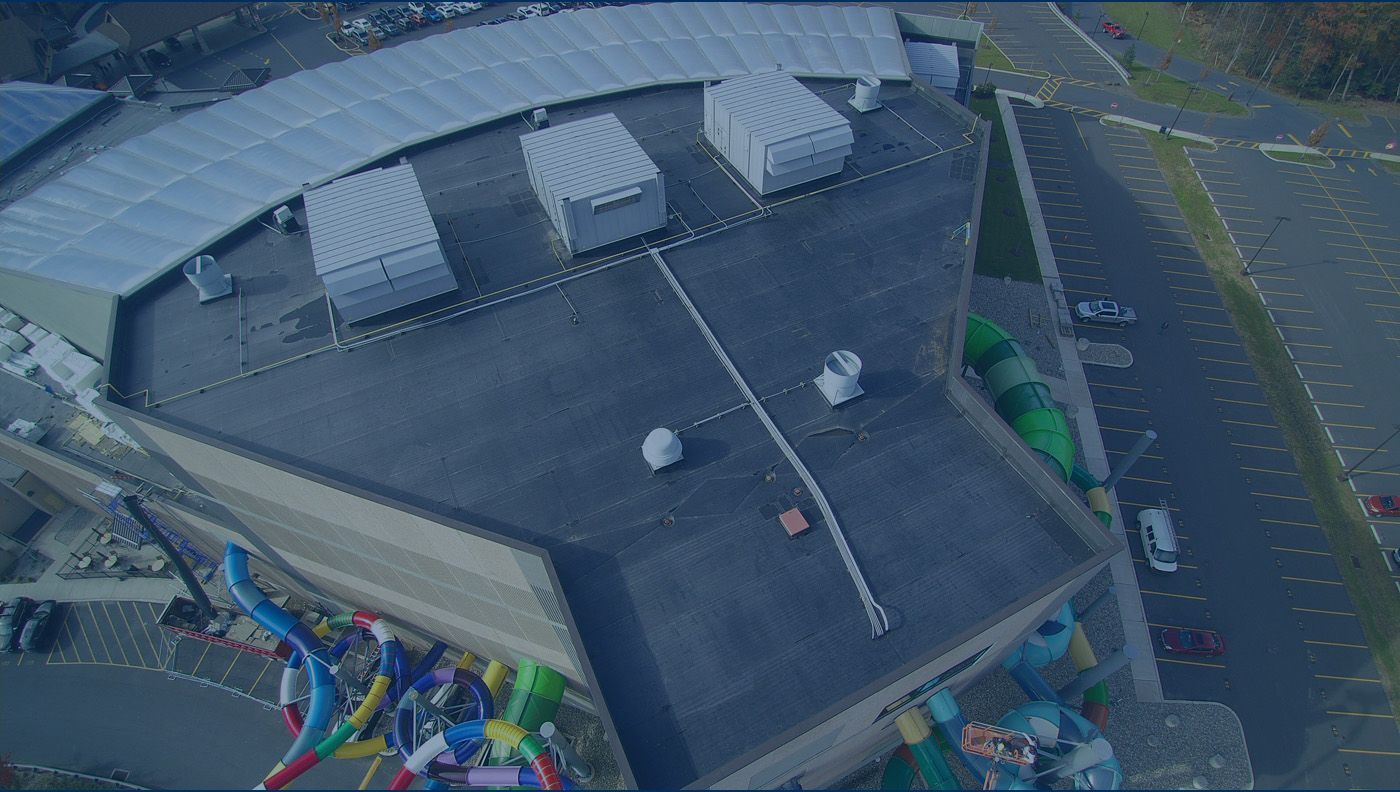An aerial view of a large building with a parking lot in front of it.