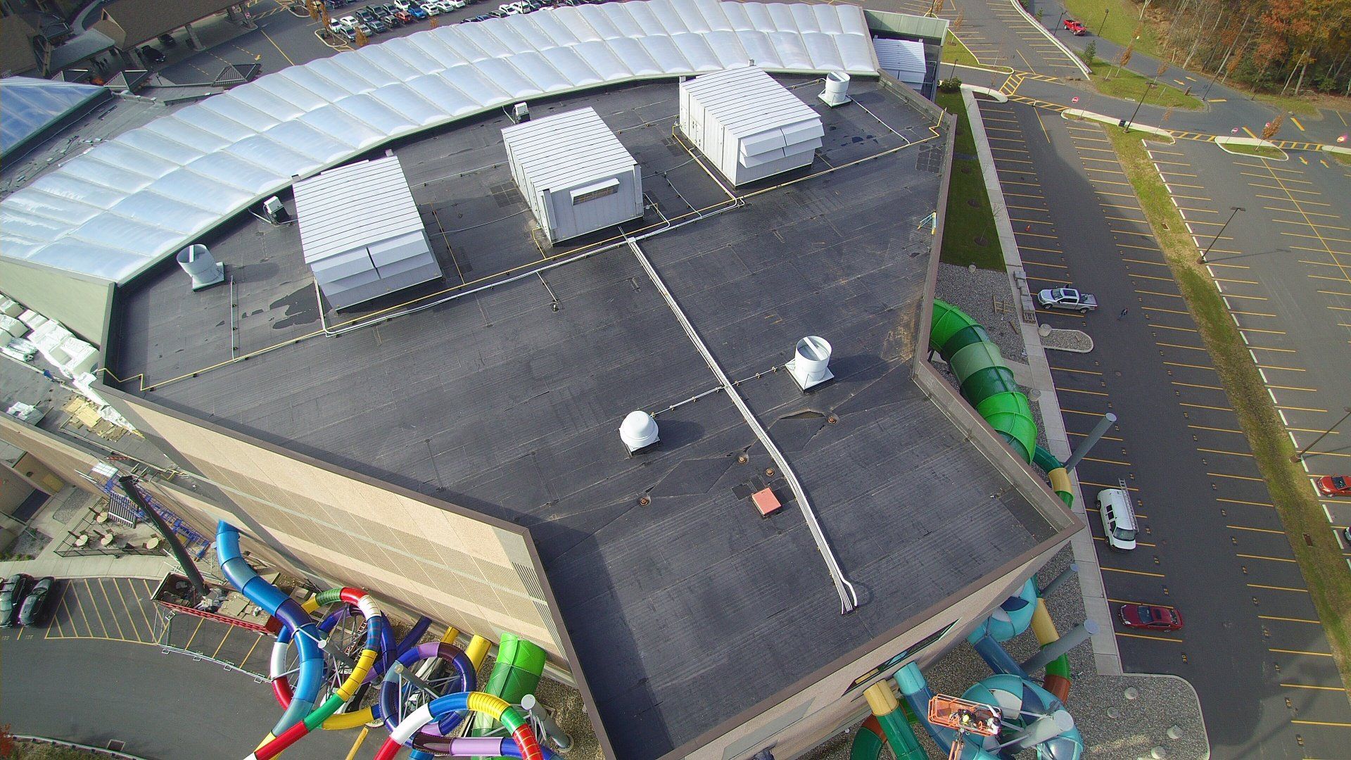 An aerial view of a large building with a water slide on the roof.