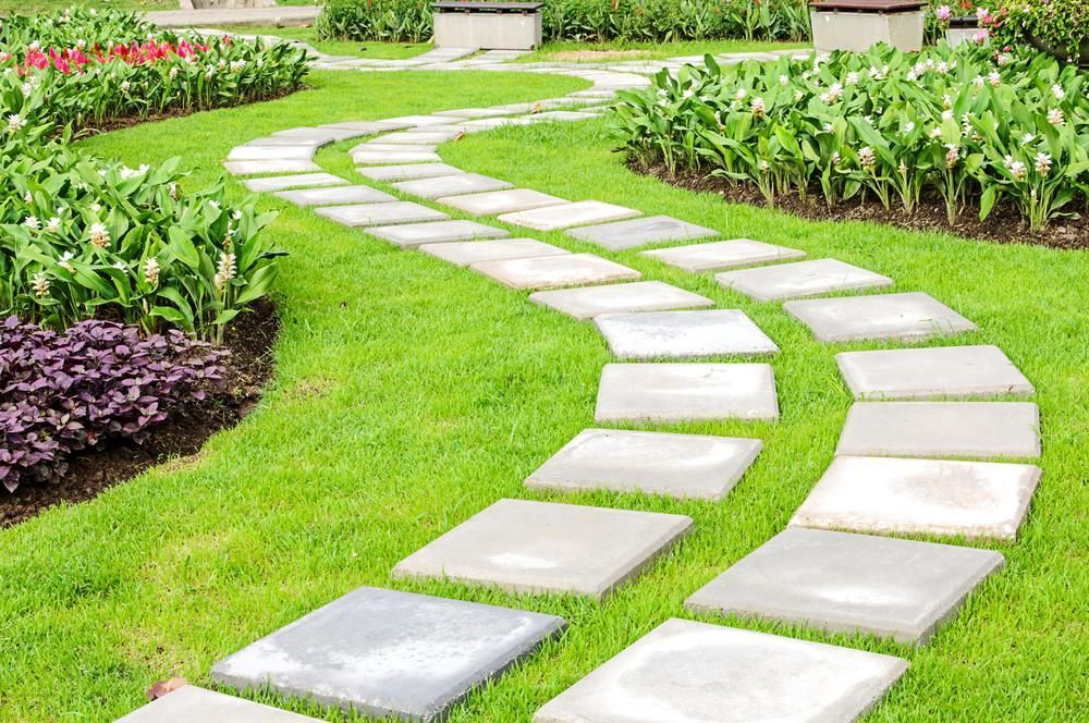 Curving Stone Path Through a Green Garden With Flower Beds — Toowoomba Lawn and Yard care In Highfields, QLD