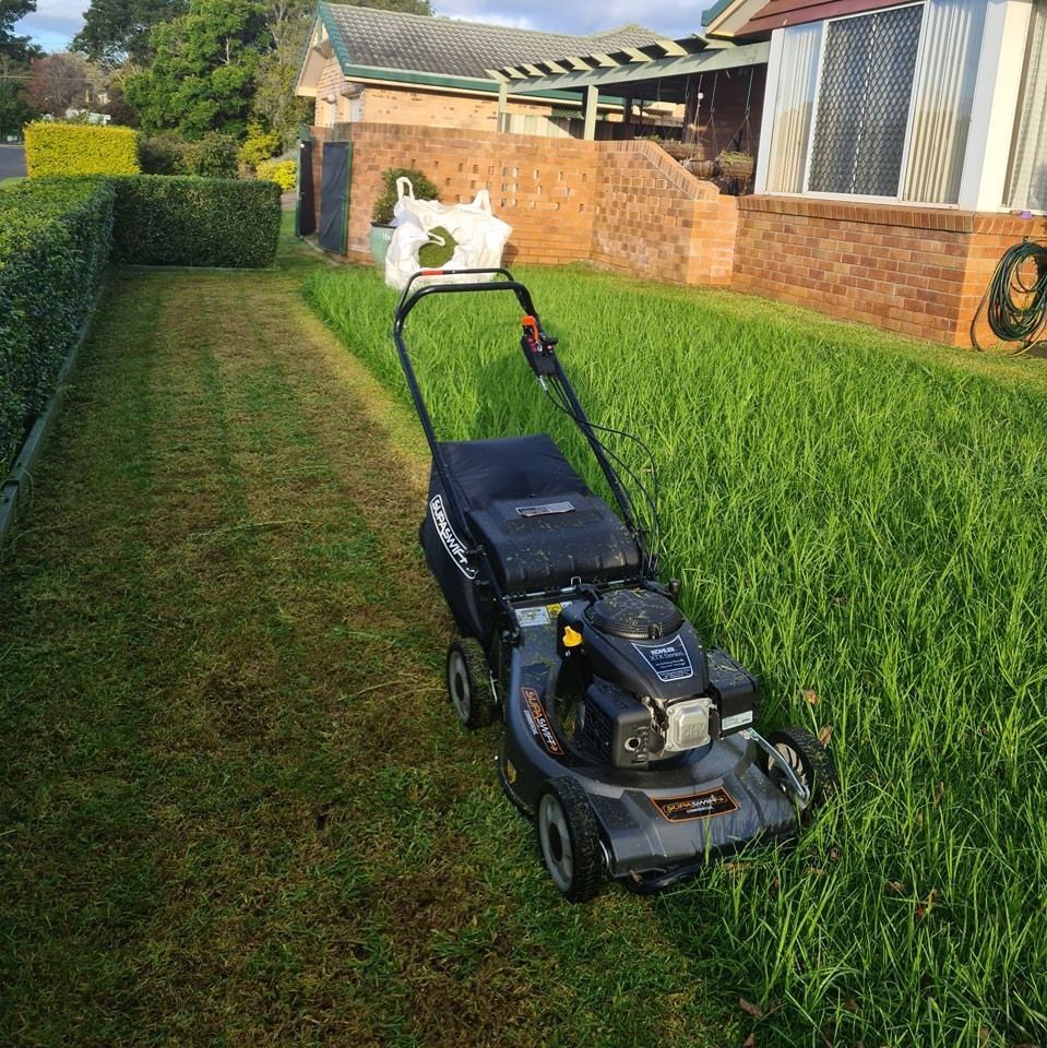 A Push Lawn Mower on a Grassy Path — Toowoomba Lawn and Yard care In Glenvale, QLD