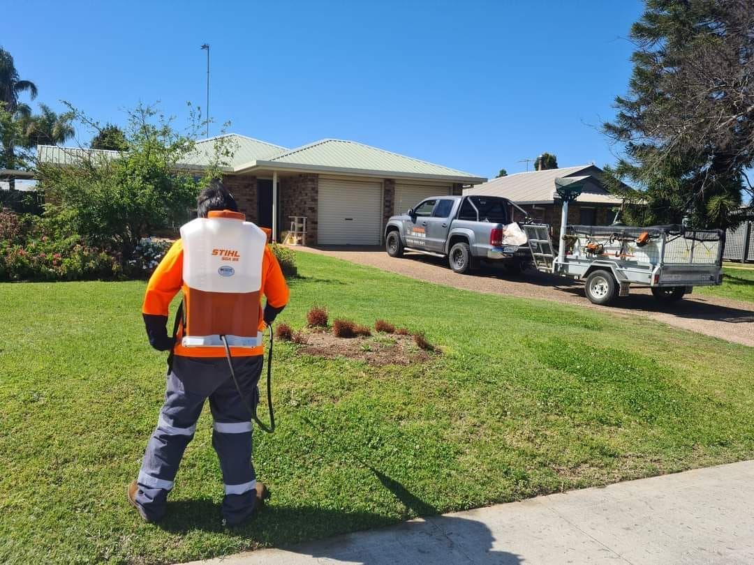 Worker in Safety Vest Stands on a Lawn Near a  Utility Trucks — Toowoomba Lawn and Yard care In Highfields, QLD