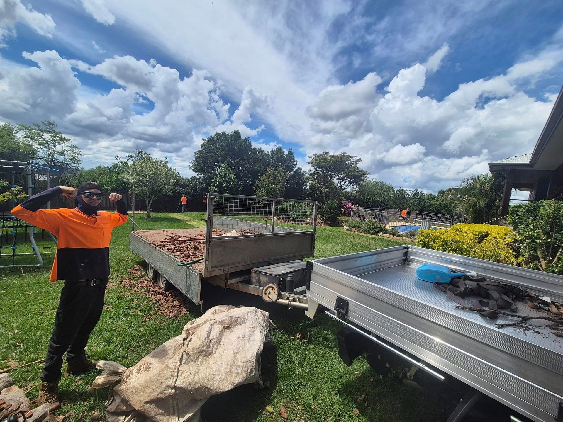 Worker in Orange Shirt Beside a Landscaped Water — Toowoomba Lawn and Yard care In Glenvale, QLD