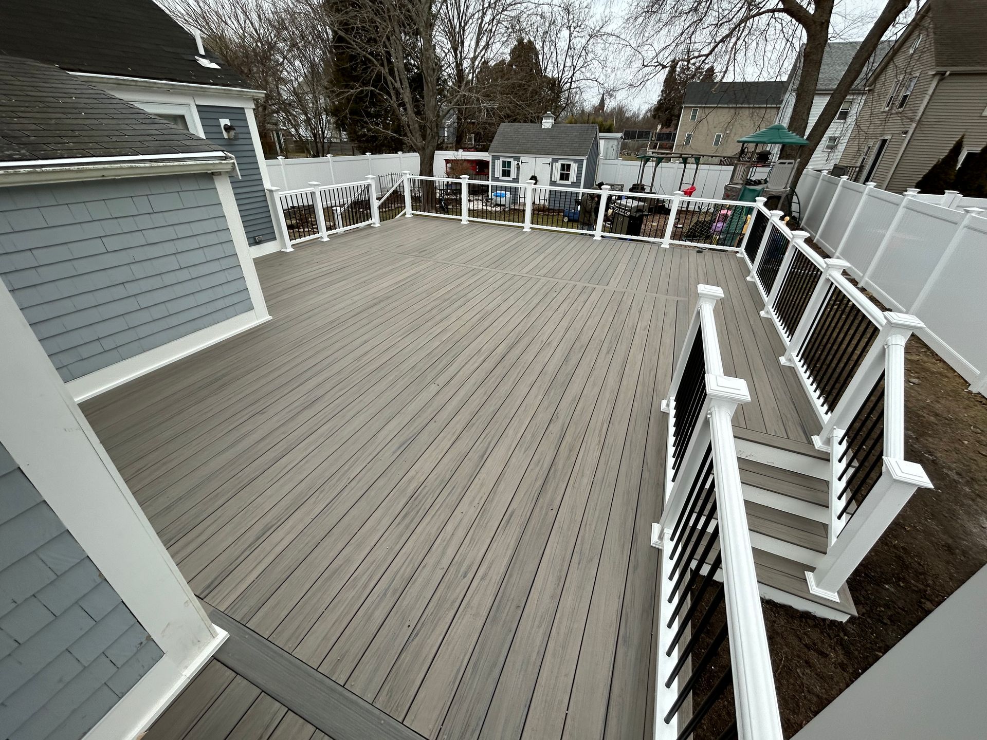 A large deck with a white railing and stairs