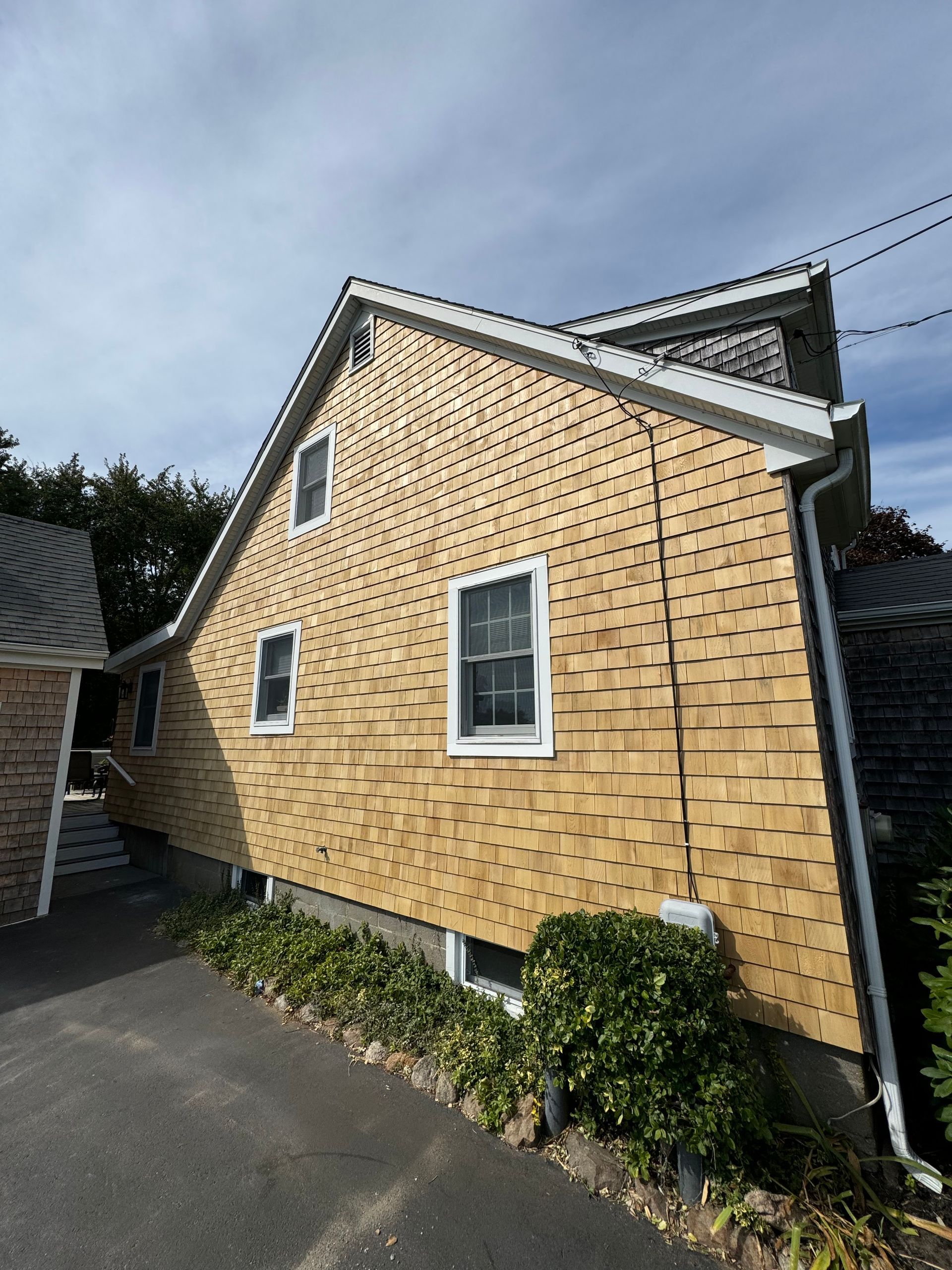 A large house with a wooden siding and white windows