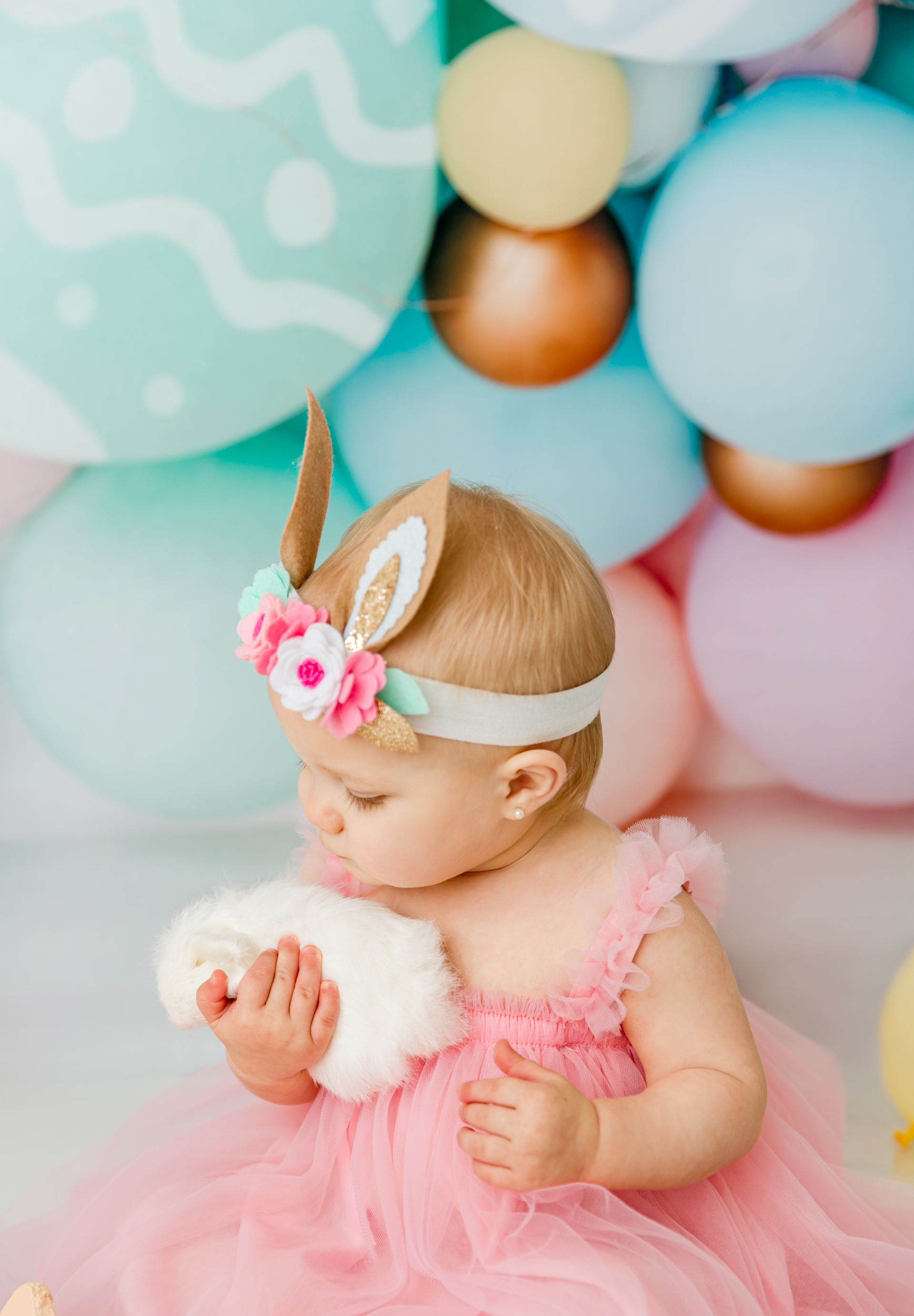 Little girl holding easter bunny toy Easter mini session in cary nc