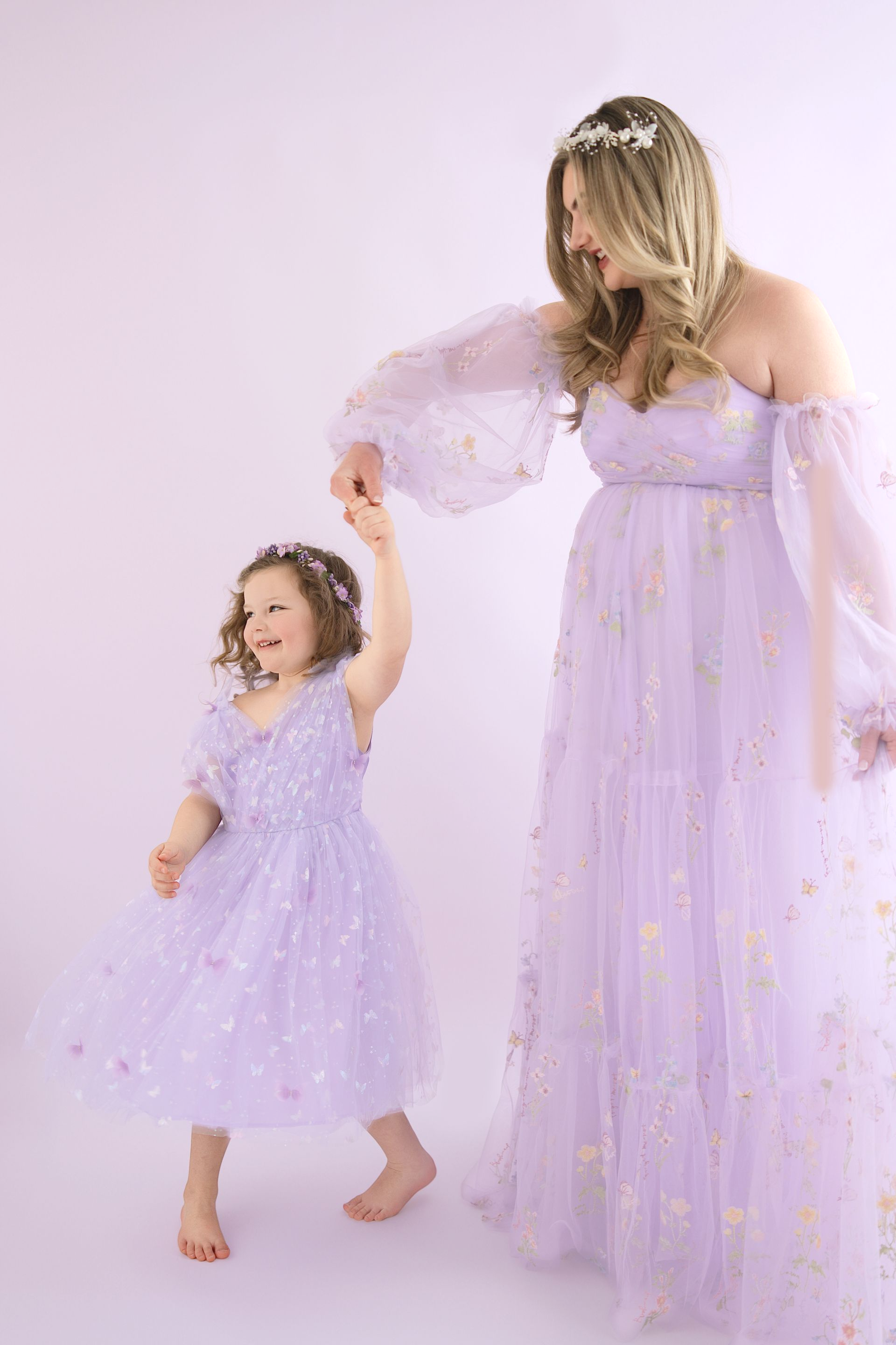 4-year-old girl twirling in her favorite purple dress during a studio photoshoot