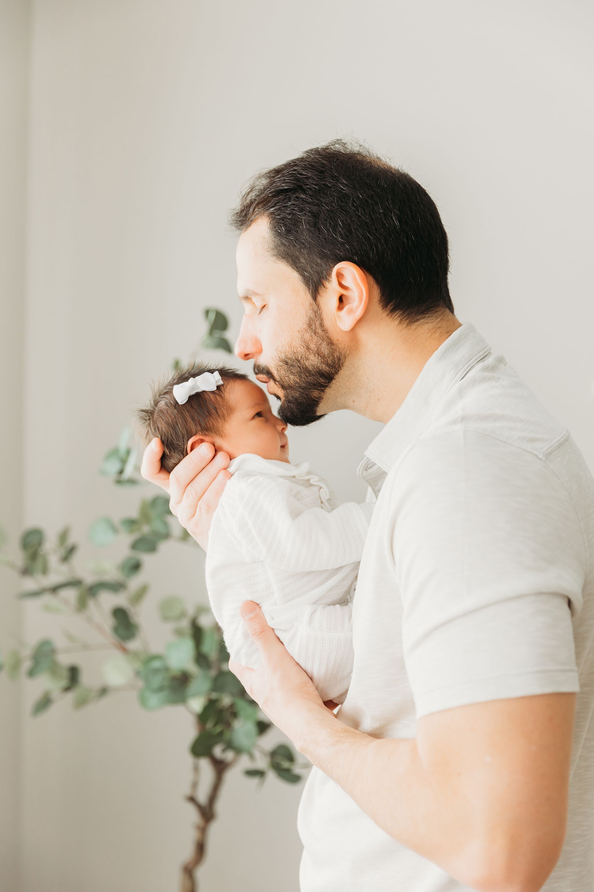 Newborn in Home session in Cary NC dad kissing the baby
