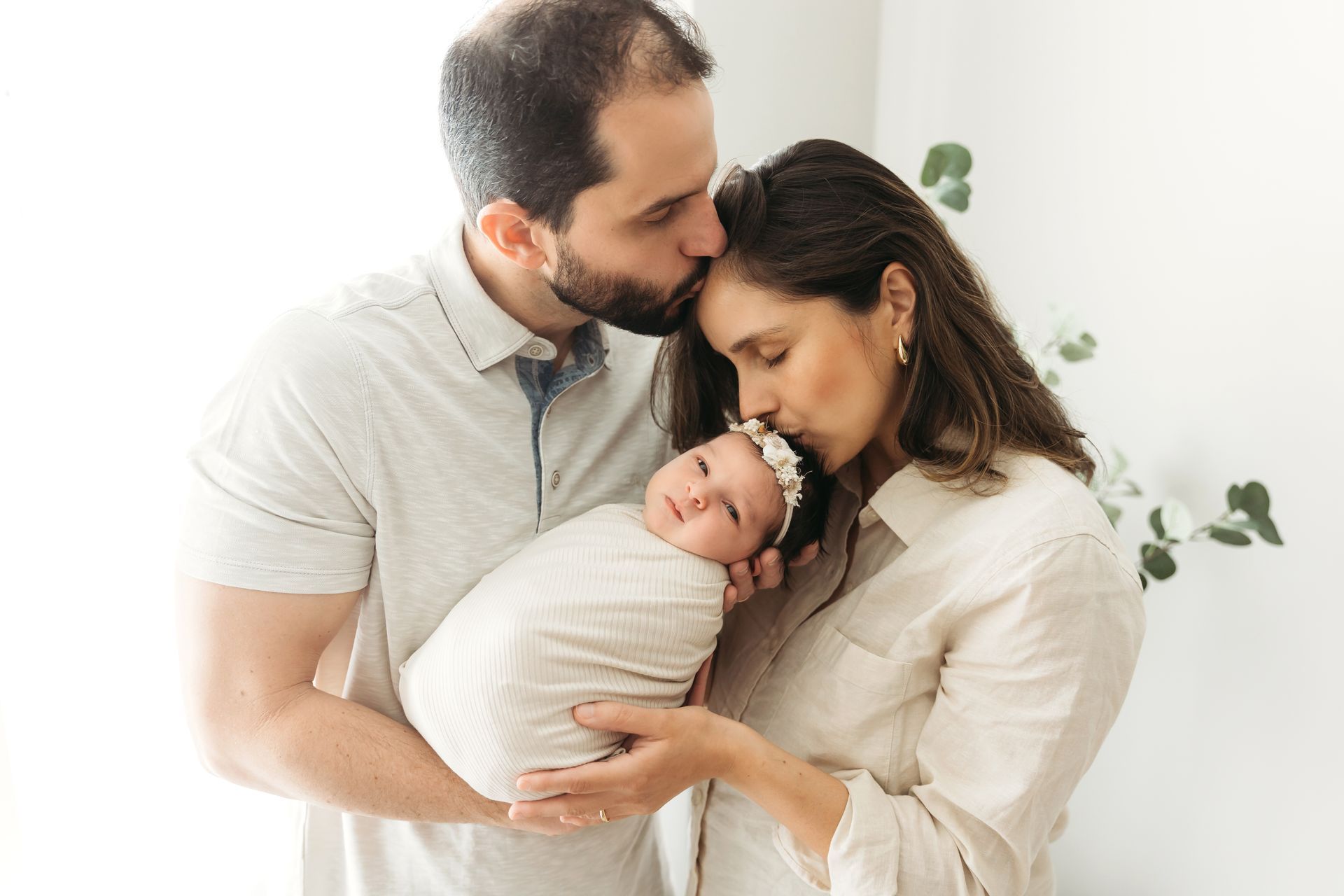 Newborn in Home session in Cary NC parents kissing the baby