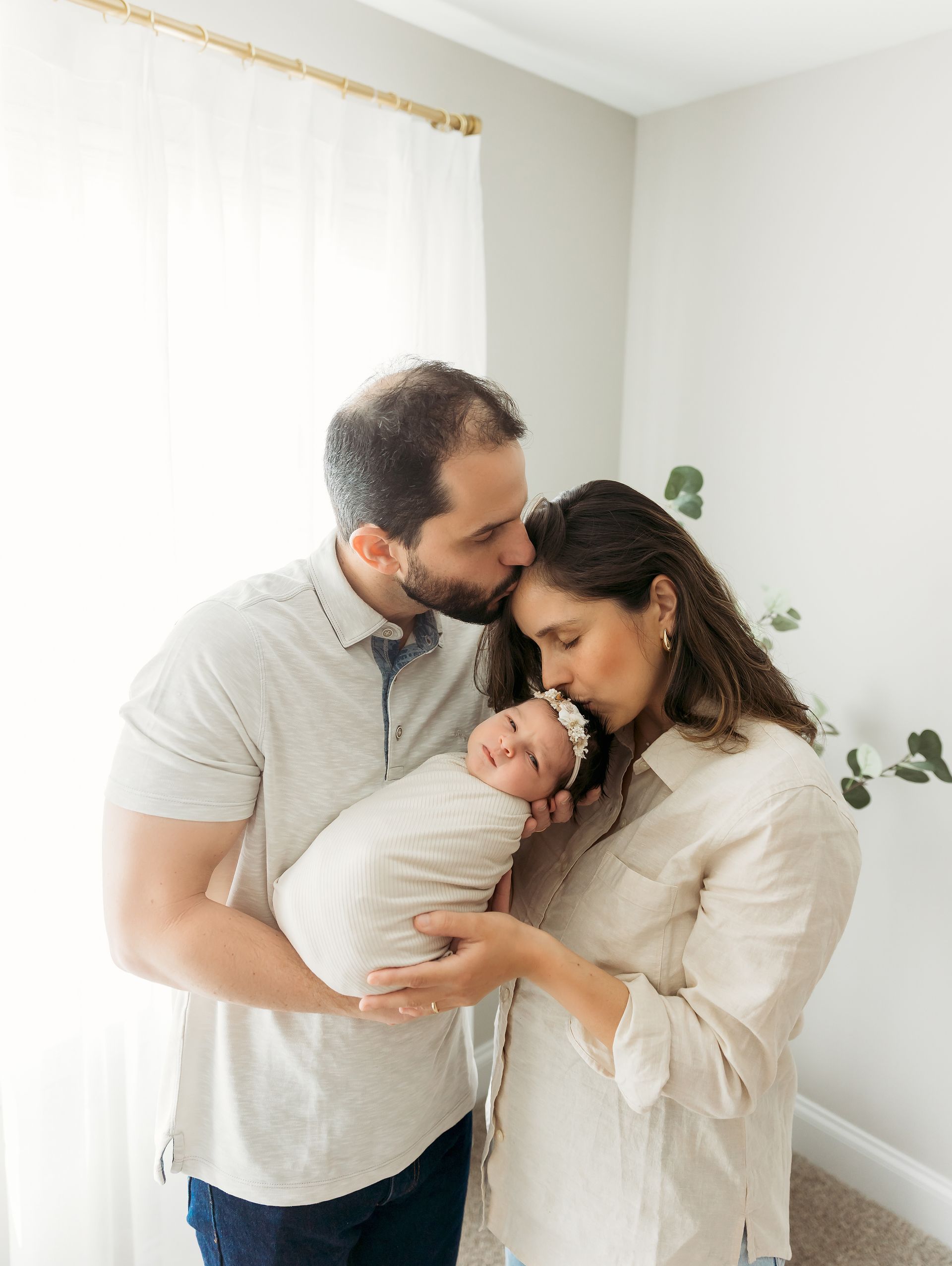 family of 3 posing during the newborn in-home portraits session in Cary NC
