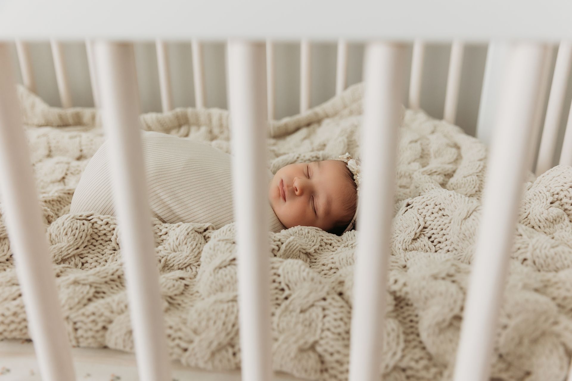 newborn peacefully sleeping in her crib during the in-home newborn session