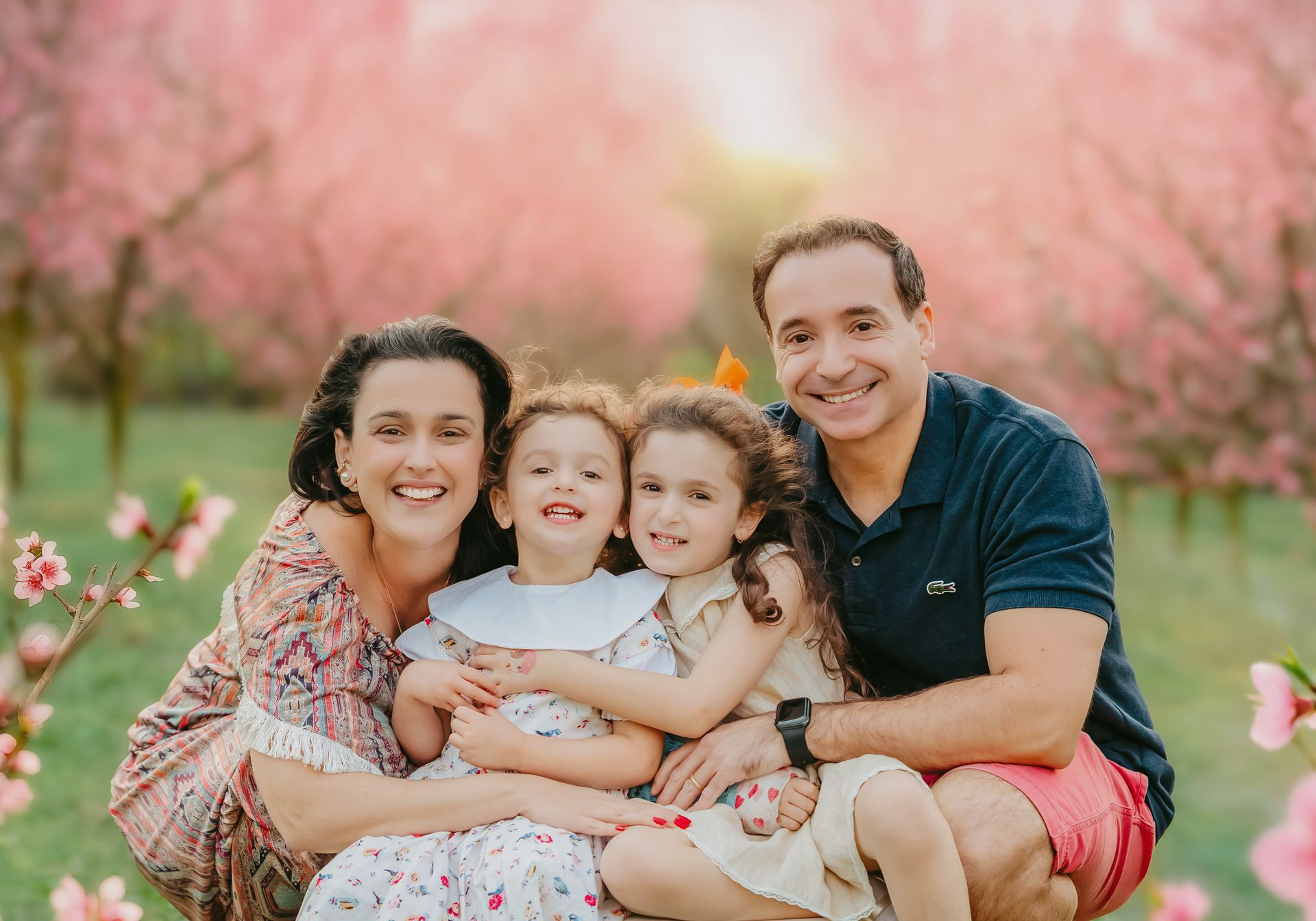 Family session in a peach blossom orchard near Raleigh on a sunny spring day