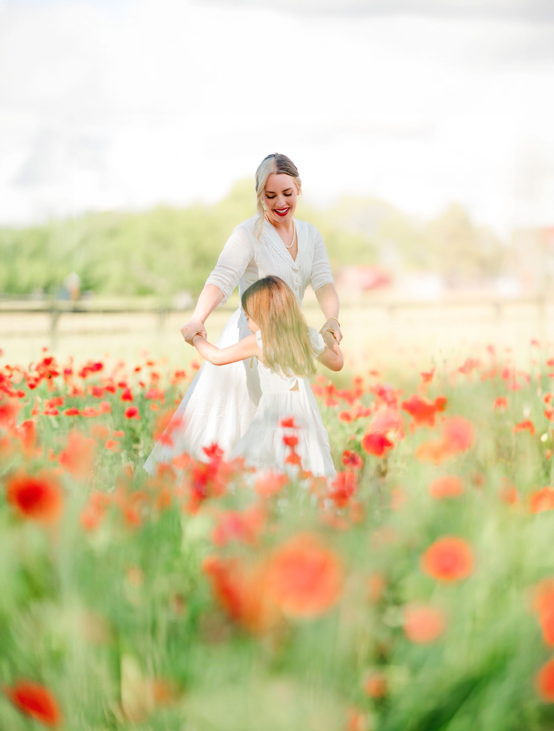 Mother’s Day portrait session in a vibrant red poppy field with natural light