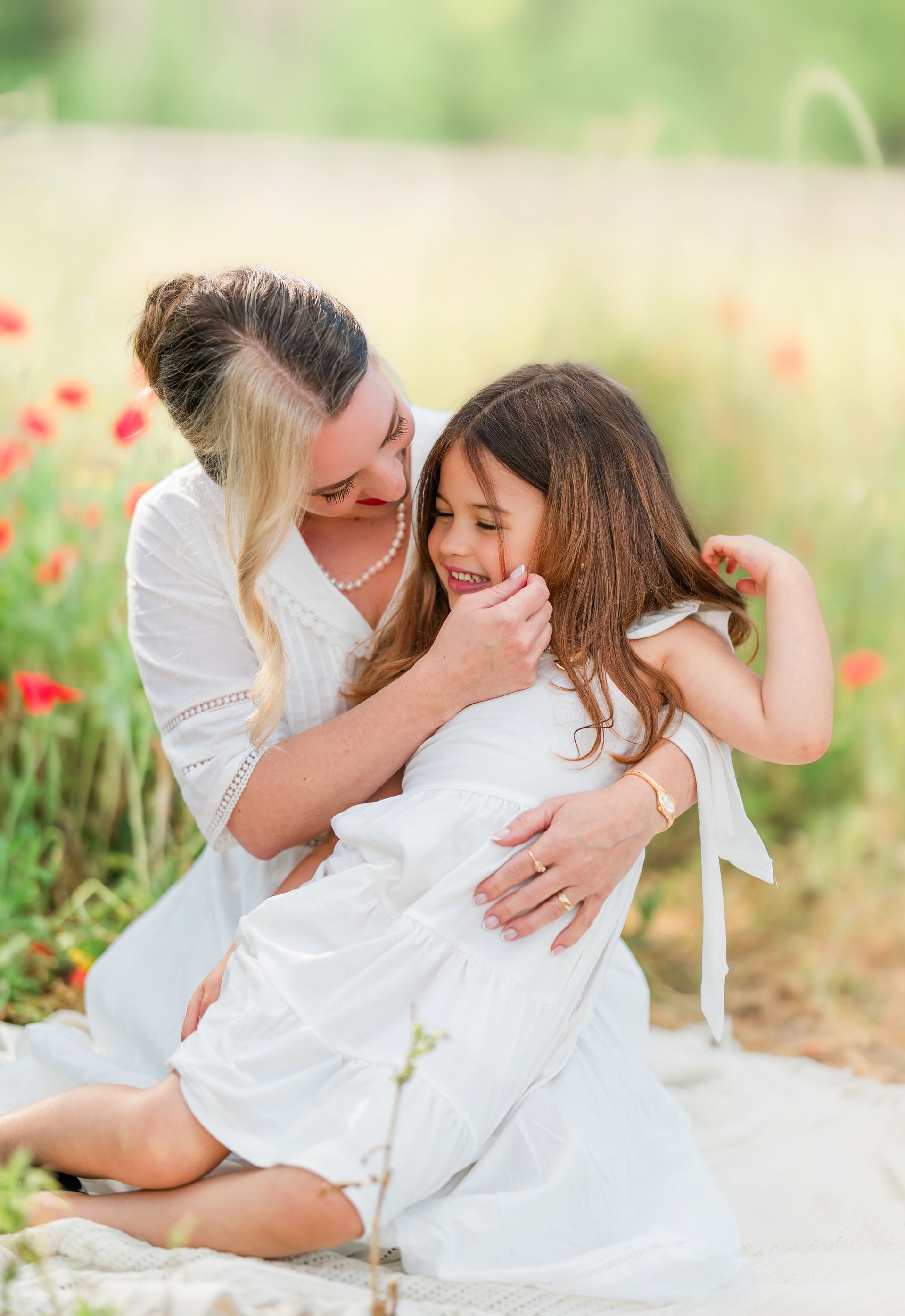 Mother and child portrait in a red poppy field on a sunny spring day in Raleigh, NC