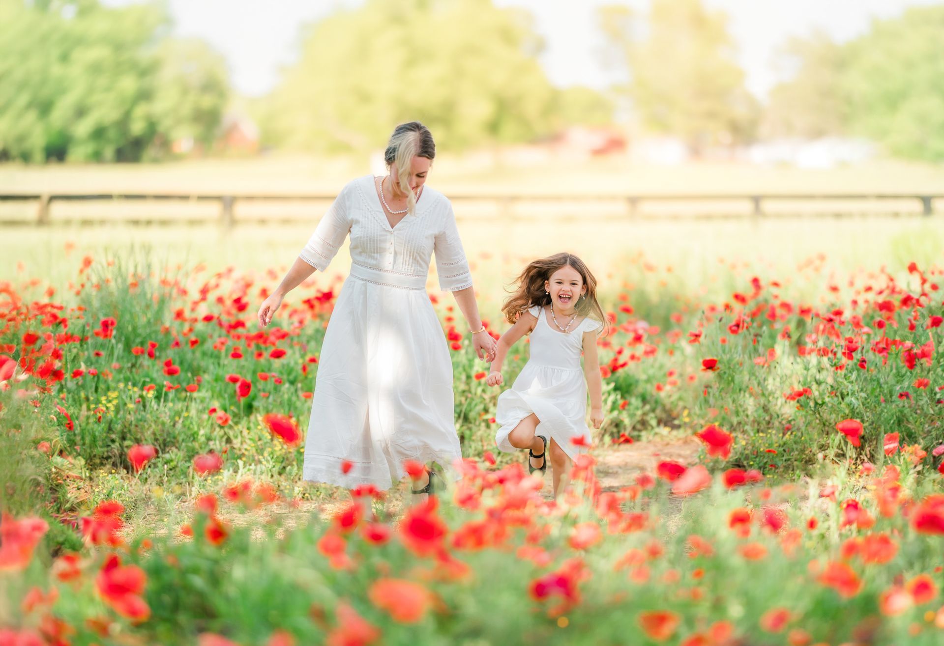 Mother’s Day portrait session in a vibrant red poppy field with natural light