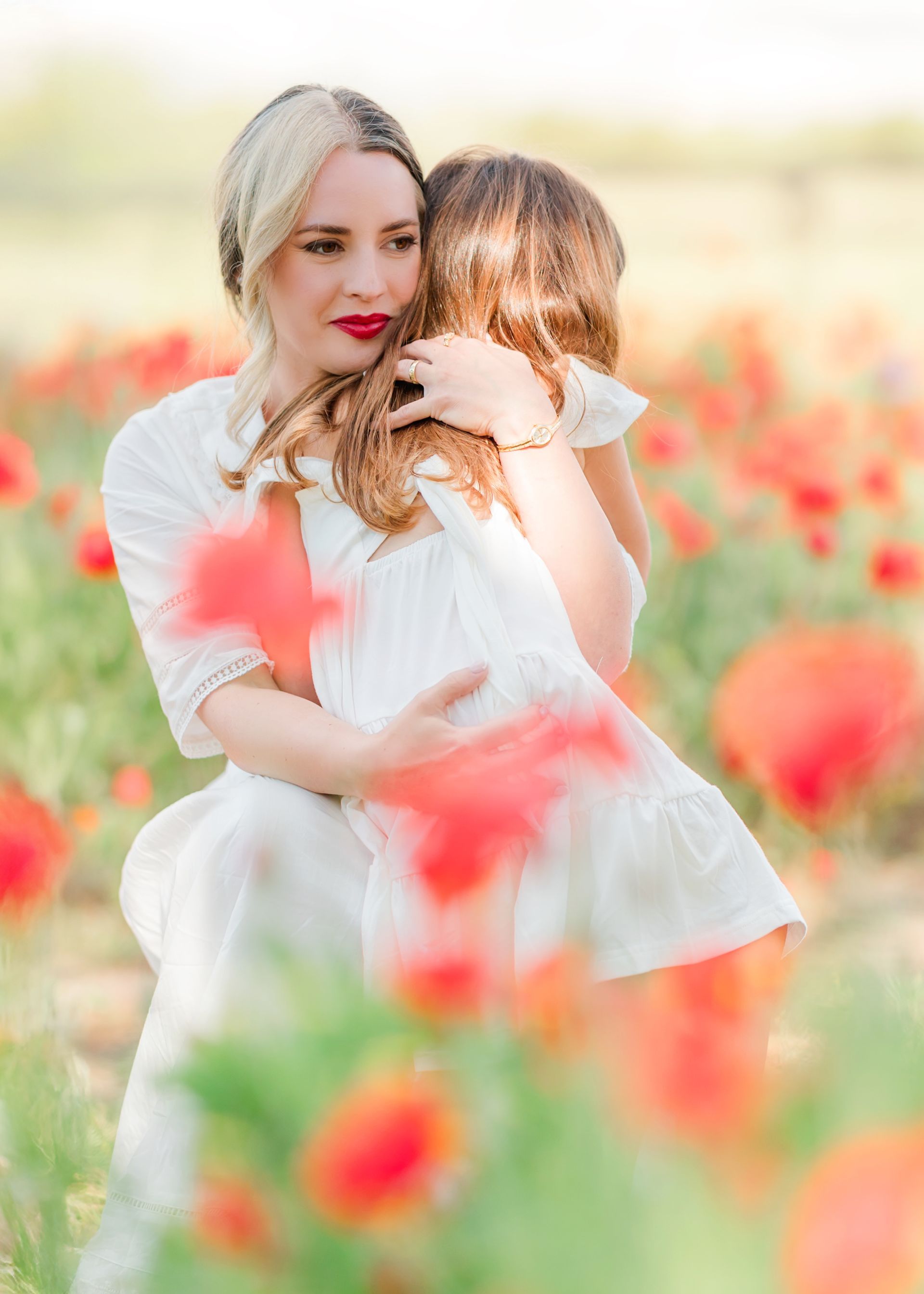 Spring portrait session in a red poppy field on a bright, sunny day in Raleigh