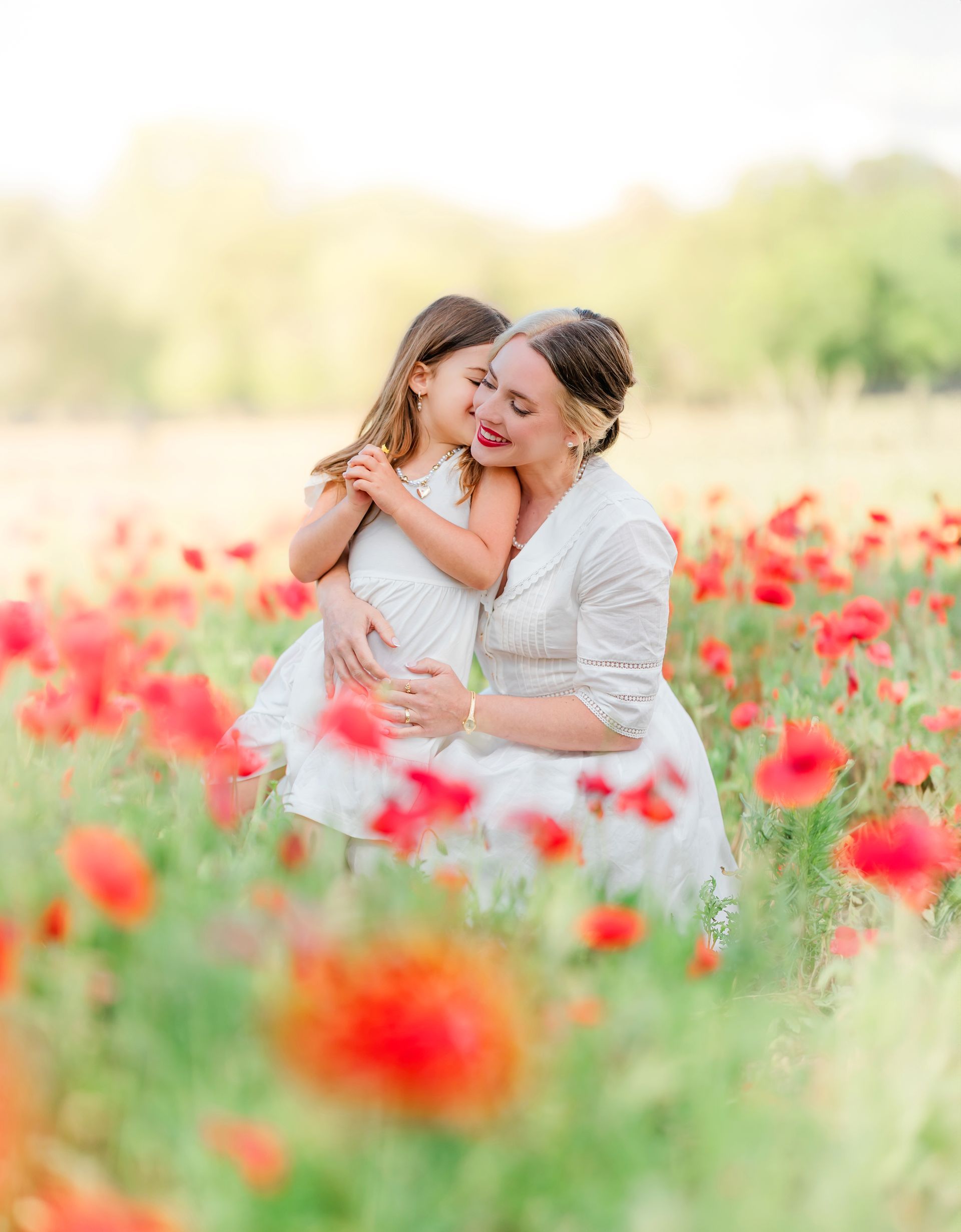 Mother and child portrait in a red poppy field on a sunny spring day in Raleigh, NC